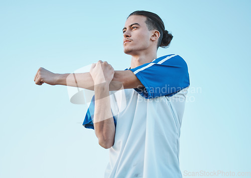 Image of Soccer, fitness and stretching with a man on a blue sky background in preparation of a game or competition. Sports, health and warm up with a young male athlete getting ready for training or practice