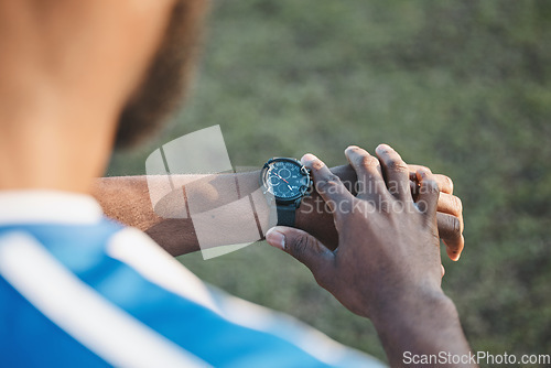 Image of Hands, man or soccer player with smart watch on field to monitor time, training or exercise progress. Wellness, performance or healthy sports athlete with timer to check running workout or fitness