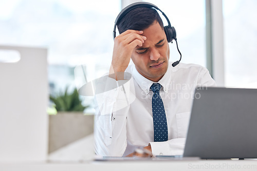 Image of Call center, working and man with a headache or businessman in customer service with stress, burnout or fatigue. Tired, exhausted or consultant in office with a migraine, pain or anxiety from crm