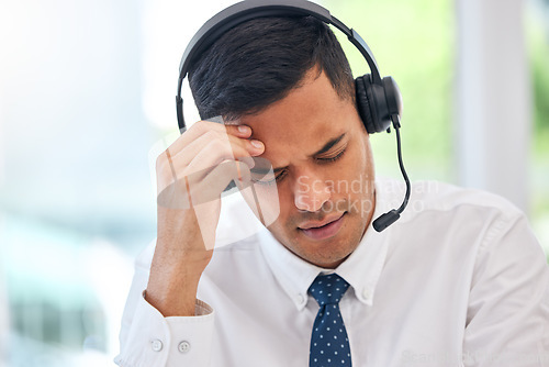 Image of Call center, customer service and man with a headache or businessman with stress, burnout or working with fatigue. Tired, exhausted or consultant in office with a migraine, pain or anxiety from crm