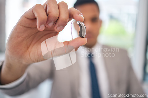 Image of Hand, business man and hearing aid for ear, sound amplifier and audio communication in company office. Professional, person with a disability and deaf with implant technology to help with listening