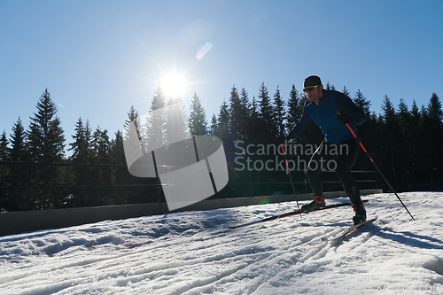 Image of Nordic skiing or Cross-country skiing classic technique practiced by man in a beautiful panoramic trail at morning.Selective focus.