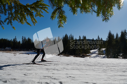 Image of Nordic skiing or Cross-country skiing classic technique practiced by man in a beautiful panoramic trail at morning.Selective focus.