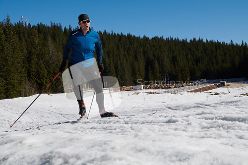 Image of Nordic skiing or Cross-country skiing classic technique practiced by man in a beautiful panoramic trail at morning.Selective focus.