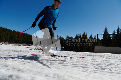 Image of Nordic skiing or Cross-country skiing classic technique practiced by man in a beautiful panoramic trail at morning.Selective focus.