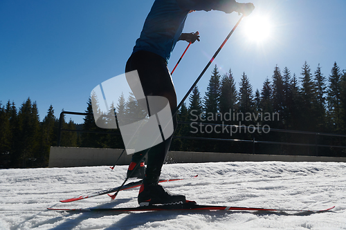 Image of Nordic skiing or Cross-country skiing classic technique practiced by man in a beautiful panoramic trail at morning.Selective focus.