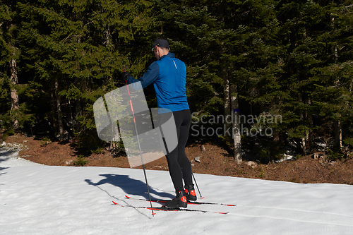 Image of Nordic skiing or Cross-country skiing classic technique practiced by man in a beautiful panoramic trail at morning.Selective focus.