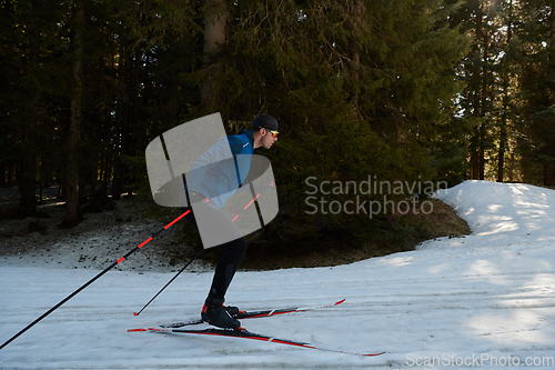 Image of Nordic skiing or Cross-country skiing classic technique practiced by man in a beautiful panoramic trail at morning.Selective focus.