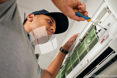 Image of Maintenance, air conditioner and man with screwdriver for problem solving on machine from below. Aircon, ac repair and handyman service with technician, electrician or contractor work on ventilation