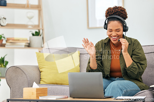 Image of Video call, wave and woman on sofa with laptop, headphones and smile in living room home office. Hello, webinar and online meeting with happy virtual assistant on couch for freelance remote work job.