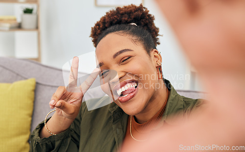 Image of Portrait, happy black woman and peace for selfie in living room, live streaming and home vlog. Face of female gen z show v sign, hand emoji and tongue out for memory, profile picture and social media