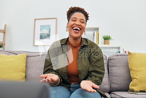 Image of Comic, happy or funny with a black woman laughing while sitting on a sofa in the living room of her home. Comedy, smile and freedom with a carefree young female person joking eyes closed in her house