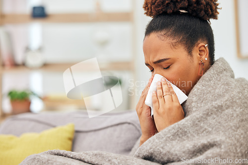 Image of Sick, woman and blowing nose with blanket in home from hayfever allergies, cold and winter virus. Face, tissue and black female person sneeze from influenza allergy, health problem and sinusitis risk