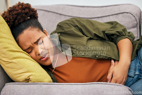 Image of Sick woman, stomach pain and problem on sofa for ibs, health risk or nausea of gastric bloating, period cramps or virus. Black female person, menstruation or stress of constipation from endometriosis