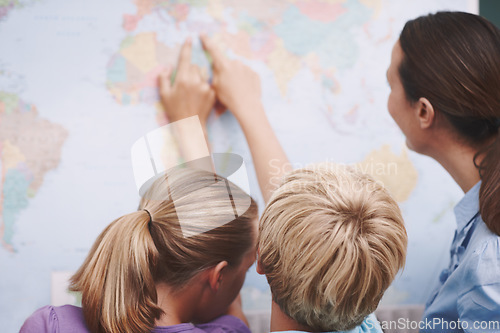 Image of Turkey. Two excited schoolchildren pointing at a world map as their teacher looks on.