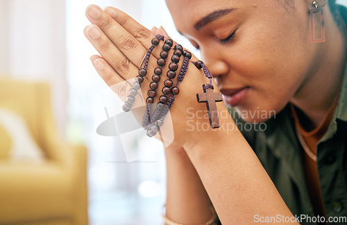 Image of Young woman, prayer and rosary in home, focus and mindfulness for faith, religion and gratitude with hope. African girl, praying hands and cross jewellery for peace, mental health or worship to God