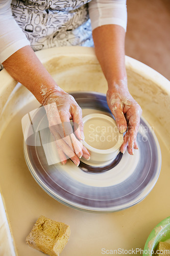 Image of Working the wheel. Cropped shot of a woman making a ceramic pot in a workshop.