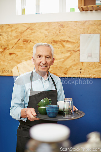 Image of Busy day at the coffee shop. Shot of a senior man working in a coffee shop.