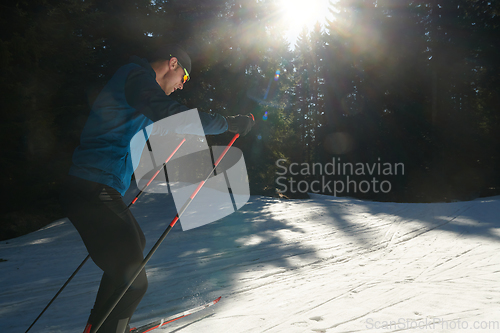 Image of Nordic skiing or Cross-country skiing classic technique practiced by man in a beautiful panoramic trail at morning.Selective focus.