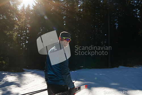 Image of Portrait handsome male athlete with cross country skis in hands and goggles, training in snowy forest. Healthy winter lifestyle concept.