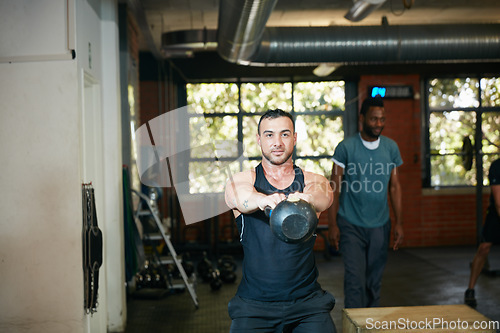 Image of I dont need machines, I am one. Shot of a young man working out with a kettle bell at the gym.