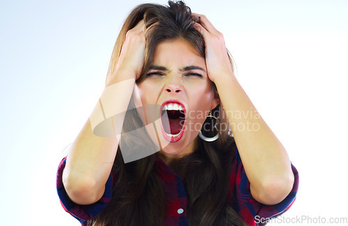 Image of Everything is falling apart. Studio shot of a young woman shouting against a white background.