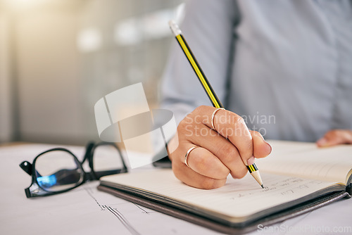 Image of Hand, book and a architect woman writing a note in her journal, diary or planner to remember an appointment. Planning, schedule and notebook with a female engineer sitting in her office closeup