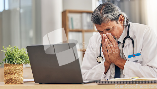 Image of Sneezing, sick and a doctor with a laptop in an office, blowing nose and an allergy at a hospital. Healthcare, medicine and a mature medical employee with a tissue with covid or a virus at work