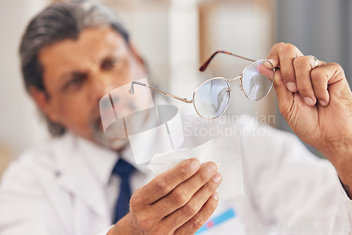 Image of Hands, medical and an optometrist cleaning glasses in his office for vision, eyesight or hygiene. Healthcare, prescription and frame lenses with a medicine professional holding eyewear in an office