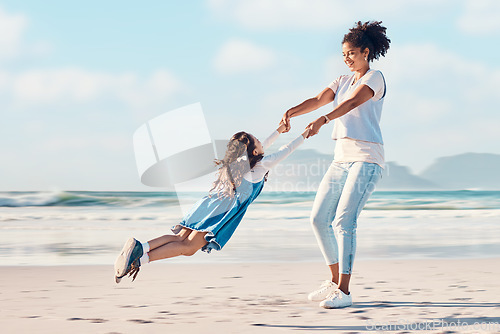 Image of Spinning, mother and a child happy at the beach while on a family vacation, holiday or adventure. A young woman or mom and girl kid playing together while outdoor for summer fun and travel in nature