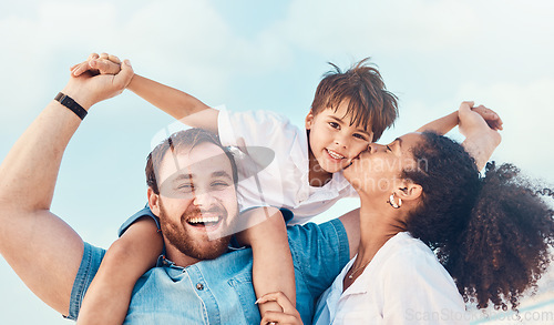 Image of Beach, father and a mother kiss child on the cheek while on a vacation, holiday or adventure. A woman, man and kid on shoulders for a portrait outdoor of summer fun and travel with multiracial family