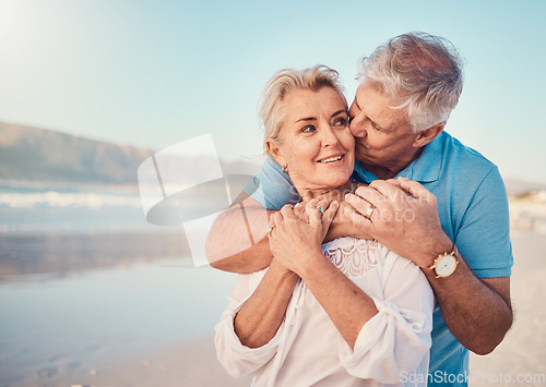 Image of Beach, love and senior couple with a kiss in nature, holiday or romantic outdoor date together at the ocean or sea. Happy, smile on face and people in a hug, embrace or happiness on anniversary