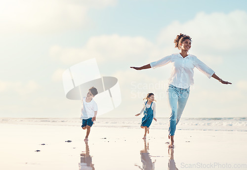 Image of Mother, son and daughter on the beach to dance together while outdoor for travel or vacation in summer. Sunset, family or children and a woman having fun with her kids on the coast by the ocean