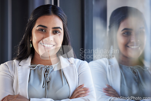 Image of Business woman, smile and happy portrait in an office with arms crossed and career pride. Face of a young female entrepreneur with confidence, positive mindset and commitment to corporate startup