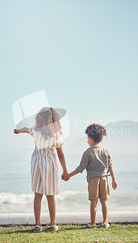 Image of Back, holding hands and a brother with his sister on the beach, looking at a view of waves together in summer. Kids, love and pointing with a girl showing a boy the horizon on blue sky mockup space