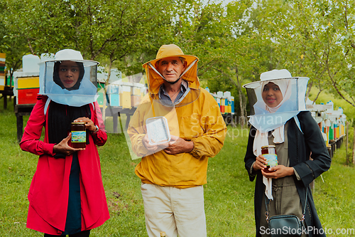 Image of Portrait of Arab investors with a beekeeper in a large honey production farm