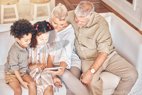 Image of Grandparents, tablet and children in home, learning and bonding together in living room. Technology, multiracial kids and grandpa and grandma in lounge streaming movie, video or film on social media