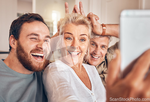 Image of Man, senior parents and selfie in home, funny and peace sign for horns, bunny ears and laugh for post on web. Family house, people and memory with profile picture, photography and social network app