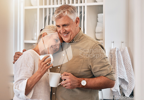 Image of Coffee, love and retirement with a senior couple hugging in their home together while bonding in the morning. Kitchen, smile or romance with a happy mature man and woman drinking tea in their house