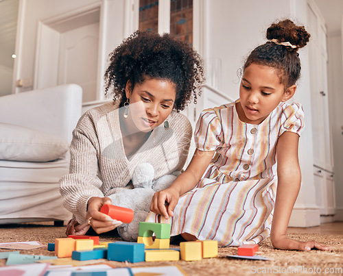 Image of Family, education and building blocks with a daughter learning from her mother on the floor of their living room. Kids, growth and toys for child development with a woman teaching a girl at home