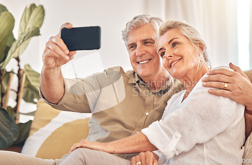 Image of Happy senior couple, hug and selfie in relax on living room sofa for photograph, memory or vlog at home. Elderly man and woman smile for picture, photo or social media post on lounge couch together
