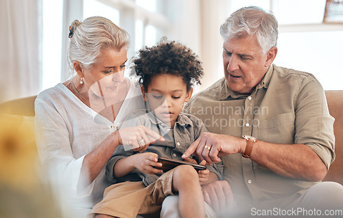 Image of Grandparents, phone and child in home pointing, learning and bonding together in living room. Smartphone, biracial kid and grandpa and grandma in lounge streaming movie, video or film on social media