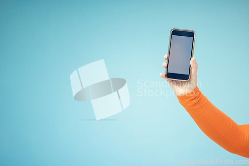 Image of Woman hand, mockup screen and phone space advertising sale, promotion or brand website or internet. Person with smartphone on blue background studio for about us, online deal or network connection