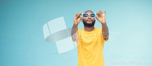 Image of Black man, sunglasses and fashion on a blue background with cool and trendy style with mock up space. Young model person with eyewear in studio for advertising designer brand, logo or color in hands