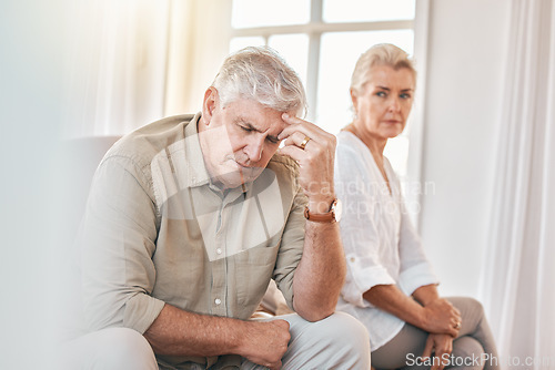 Image of Senior couple, divorce and headache in conflict, fight or argument on the living room sofa at home. Elderly woman and frustrated man in depression, cheating affair or toxic relationship in the house