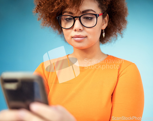 Image of Woman, cellphone and mobile texting on blue background for social media, technology and network. Young female with smartphone technology in studio for connection, reading notification and website app