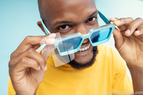 Image of Black man, sunglasses and comic face portrait on blue background with cool and trendy style or fashion. Happy young model person with glasses in studio for advertising designer brand, logo or color