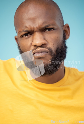 Image of Portrait, doubt and expression with a black man in studio on a blue background feeling annoyed or frustrated. Face, confused and frown with a handsome young male indoor looking upset or unhappy