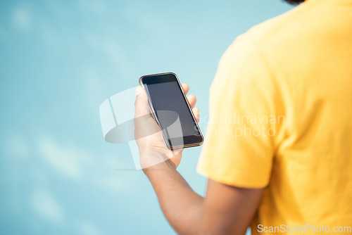 Image of Hand, phone and mockup screen with man reading sale, promotion or email for brand on website. Person with smartphone on blue background in studio for about us, online contact or network connection