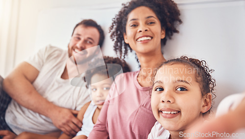 Image of Happy family, smile and selfie on bed at home for quality time, bonding or morning. Portrait, mixed race and profile picture of a man, woman and children in a bedroom with love, care and comfort